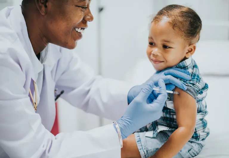 Clinician giving a child a vaccination