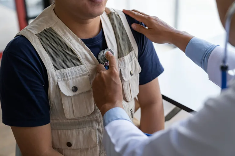 Clinician listening to a patient's chest with a stethoscope