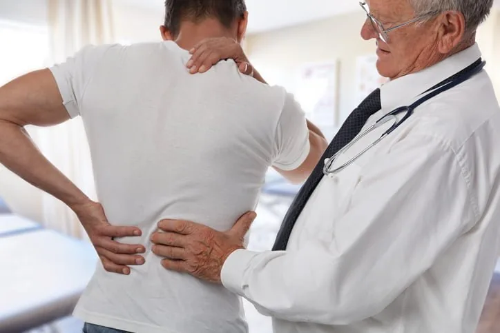 Clinician examining a patient's back